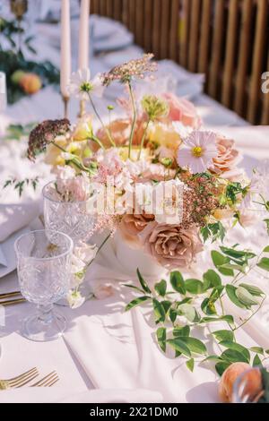 Sunlit outdoor wedding table setting with blush florals Stock Photo