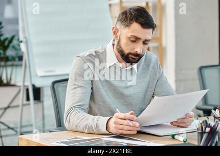 A man in business attire sitting at a desk, intensely focusing on writing notes with a pen on a piece of paper. Stock Photo