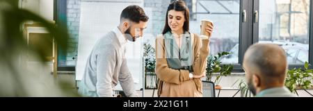 A man and woman engrossed in a cell phone, collaborating on a project in a corporate office setting. Stock Photo
