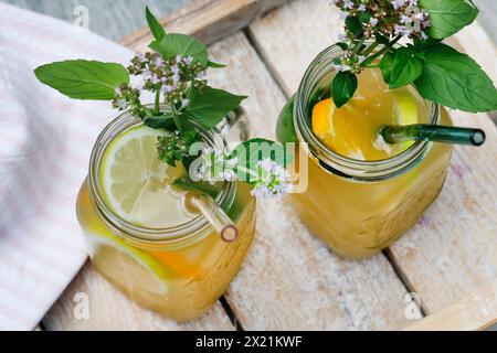 Homemade iced tea made from herbal tea with apple juice, orange juice, water mint, wild marjoram, Step 5: ready-made iced tea, garnished with wild ori Stock Photo