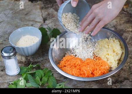 Making vegan herb patties, step 2: Ingredients are mixed; cooked buckwheat, fresh wild herbs, grated potatoes, grated carrots, chickpea flour, fine ro Stock Photo