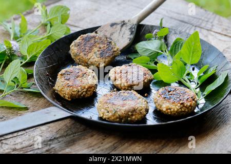 Making vegan herb patties, step 5: Ready-made herb patties arranged on a plate, serial image 5/5 Stock Photo