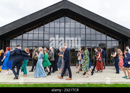 Wedding guests friends and family walking outside to a reception ceremony at a wedding at Botley Hill Farm in Surrey, UK Stock Photo