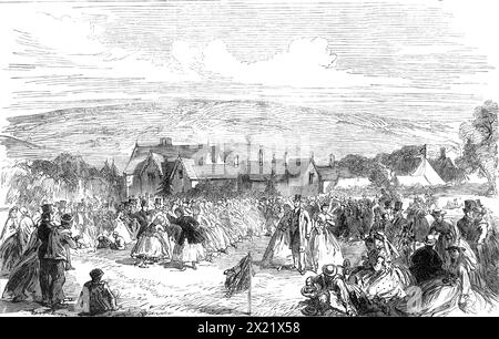 Harvest-Home at Bywell, Northumberland, 1865. 'The pleasant and rational custom of holding a village festival to accompany the due thanksgiving service in the parish church on the completion of harvest is spreading widely, of late years...[After the service at St. Peter's Church, Bywell,] ...all went in procession to the field where the dances and games were to take place, beginning with a country dance to the tune of "Corn Rigs," the next dance being a reel to the tune of "Speed the Plough." Running-races, hurdle-races, and leaping-matches, for such prizes as a pig, a spad Stock Photo