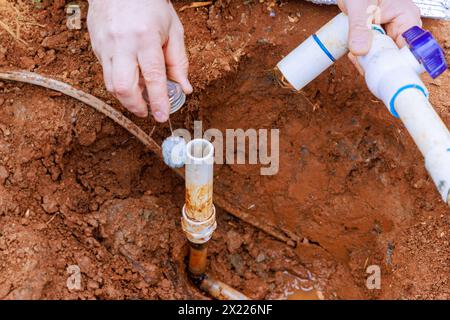 Before gluing pipes together, technician plumbers use clear primer for PVC pipe Stock Photo
