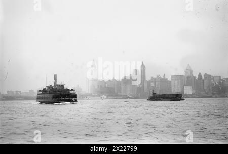 Skyline - N.Y.C.: Woolworth Bldg., Singer Bldg., Bankers Trust Bldg., (1912?). Shows Lower Manhattan, New York City, with ferry in foreground. Identified buildings include (from left): Woolworth Building (with tower nearing completion), Hudson Terminal, West Street Building, City Investing Tower, Singer Building, U.S. Realty and Trinity buildings, United States Express Company, Bankers Trust Tower, and 47 West Street Building. Stock Photo