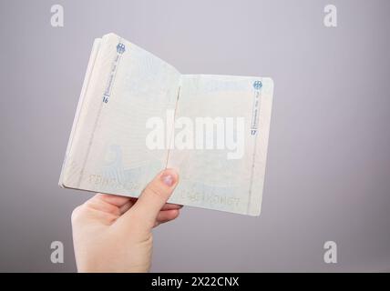 Close up of a female hand holding an open German passport Stock Photo