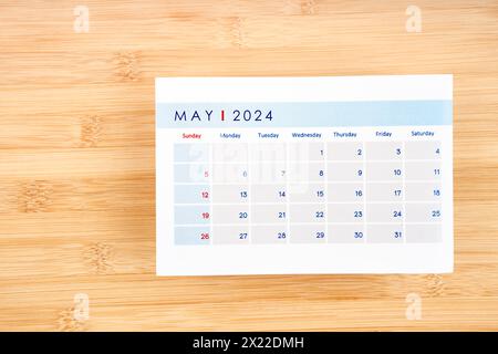 May 2024 calendar page on wooden background with empty space. Stock Photo