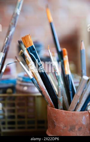Different brushes in drawing studio interior. Close up view , vertical shot Stock Photo