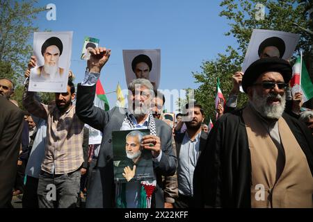 April 19, 2024, Tehran, Iran: Iranians carrying placards and portraits of the Iranian former supreme leader Ruhollah Khomeini and former Iranian major general Qasem Soleimani, who was killed in a US drone strike in Baghdad on January 3, 2020, during an anti-Israel rally in Tehran. Air defense systems over the central city of Isfahan destroyed three aerial objects early on April 19. The explosions come after a drone and missile attack carried by Iran's Islamic Revolutionary Guards Corps (IRGC) towards Israel on April 13, following an airstrike on the Iranian embassy in Syria, which Iran claimed Stock Photo
