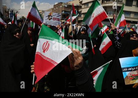 April 19, 2024, Tehran, Iran: Iranian women wave Iran flags during an anti-Israel rally in Tehran. Air defense systems over the central city of Isfahan destroyed three aerial objects early on April 19. The explosions come after a drone and missile attack carried by Iran's Islamic Revolutionary Guards Corps (IRGC) towards Israel on April 13, following an airstrike on the Iranian embassy in Syria, which Iran claimed was conducted by Israel.Credit: Zuma Press/Alamy Live News Stock Photo