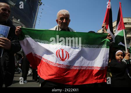 April 19, 2024, Tehran, Iran: An Iranian man holds a flag of Iran during an anti-Israel rally in Tehran. Air defense systems over the central city of Isfahan destroyed three aerial objects early on April 19. The explosions come after a drone and missile attack carried by Iran's Islamic Revolutionary Guards Corps (IRGC) towards Israel on April 13, following an airstrike on the Iranian embassy in Syria, which Iran claimed was conducted by Israel.Credit: Zuma Press/Alamy Live News Stock Photo