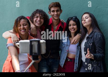 Group of young Latino college students outside of class taking pictures and having a good time Stock Photo