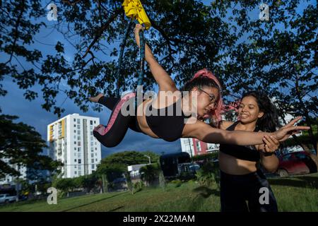 Two young Latin American women practice on the open-air aerial hoop Stock Photo