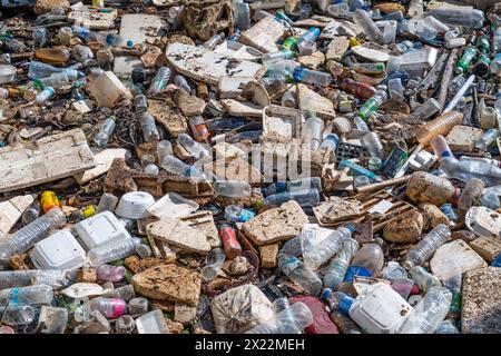 Large blockage pile of garbage stretches parallel to the river - plastic, rubber, and others. Waste petroleum products are the main ones Stock Photo