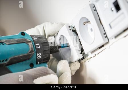 Electrician Installing Another Wall Mounted Power Outlet Close Up Photo Stock Photo