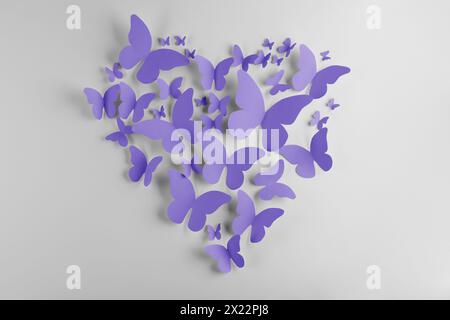 Heart made of violet blue paper butterflies on white wall Stock Photo