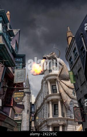 Universal Studio Orlando. , Harry Potter world, the dragon above Gringotts bank in Diagon Alley breathes fire and smoke with a moody sky. Theme Park Stock Photo