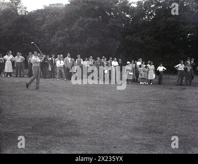 1954, historical, English golfer, Henry Cotton a hitting shot from a tree-lined fairway on an inland golf course, possibly the Dunlop Tournament at Wentworth, England, UK, which he won. Henry Cotton was a three-winner of the British Open. Stock Photo