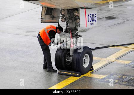 AUGUSTO C. SANDINO Airport, Managua, Nicaragua, An airport employee checks the landing gear of an aircraft at the gate, Central America, Central Stock Photo