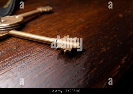 bronze colored key on a wooden furniture Stock Photo