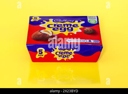Box of Cadbury Creme Eggs on yellow background with partial reflection Stock Photo