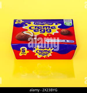 Box of Cadbury Creme Eggs on yellow background with partial reflection Stock Photo