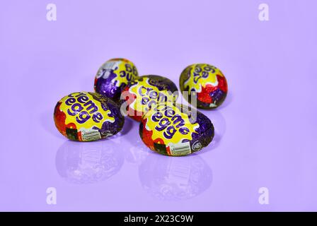 Five Cadbury Creme Eggs on a light purple background, Easter Eggs Stock Photo