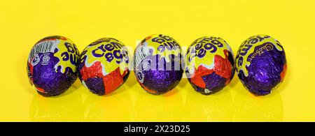 Five Cadbury Creme Eggs in a row on Yellow Background, Easter Eggs. Panoramic image Stock Photo