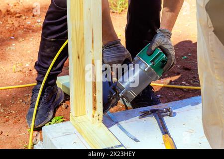 Framer uses an air nail hammer to install beams in wooden frame Stock ...