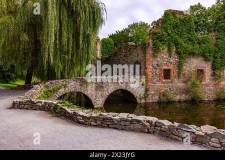Dreamy ruins with a historical ambience in the picturesque Schöntal city park under old trees, ancient arches and cloudy skies Stock Photo