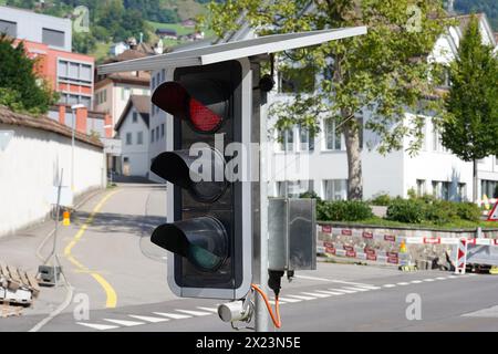 Portable traffic light powered by solar panels situated on the road to guide traffic during construction work in Schwyz, Switzerland. Stock Photo