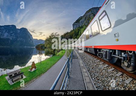 Train runs along Lake Hallstatt, Dachstein in the background, Salzkammergutbahn, Salzkammergut, Upper Austria, Austria Stock Photo