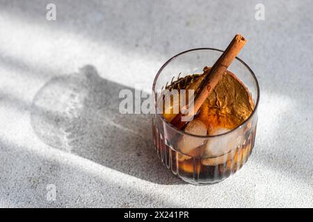 Apple cider with ice cubes, apple slices and cinnamon sticks Stock Photo