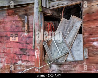 A window filled with debris is a reminder of the disrepair of an old boat yard on San Juan Island in Washington. Stock Photo