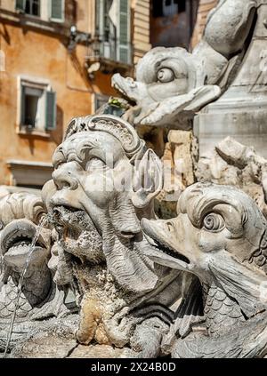 The whimsical fountain at the Fontana del Pantheon in Rome features water coming from men and fish. Stock Photo