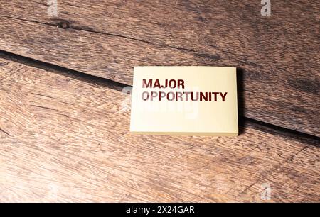Closeup on businessman holding a card with text MAJOR OPPORTUNITY, business concept image with soft focus background and vintage tone Stock Photo