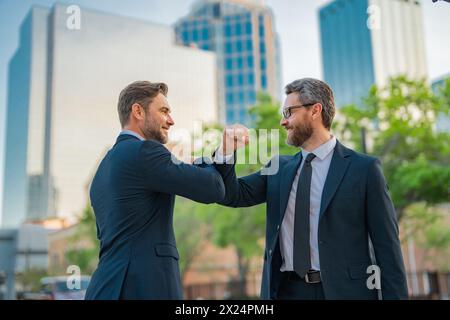 Welcome business. Two businessmen shaking hands. Business men in suit shaking hands outdoors. Handshake between two businessmen. Greeting, dealing Stock Photo