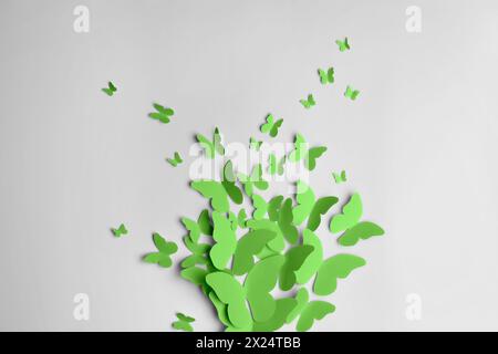 Bright green paper butterflies on white wall Stock Photo