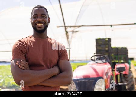 African American male farm supervisor with crossed arms in hydroponic greenhouse Stock Photo