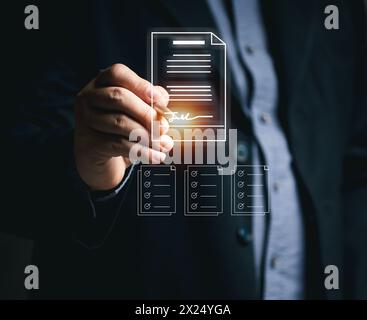 Businessman signs documents to approve work online using mobile virtual screen. Electronic signature and paperless office concept. E-signing. Technolo Stock Photo