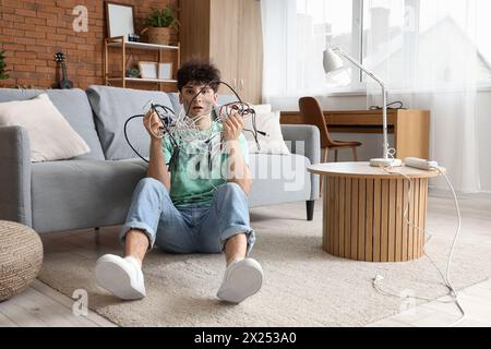 Electrocuted young man with burn face and wires at home Stock Photo