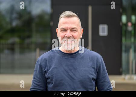 Portrait of a middle aged man looking friendly to camera wearing a blue sweater Stock Photo