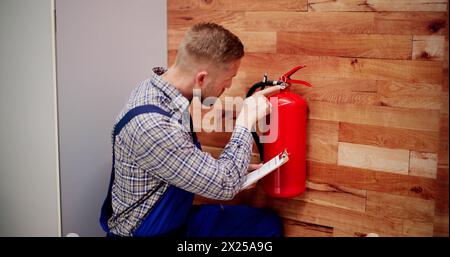 Close-up Of Male Professional Checking A Fire Extinguisher Stock Photo