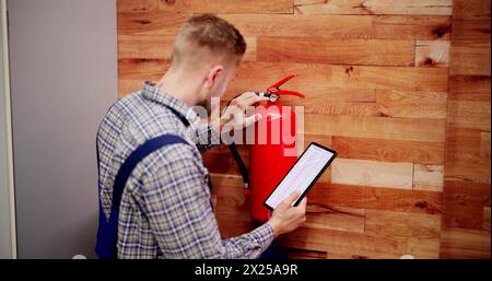 Fire Extinguisher By Handyman. Portable Extinguish Equipment Checking Stock Photo