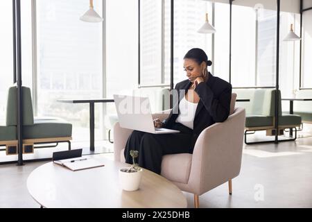 Pensive young African American businesswoman typing on laptop Stock Photo