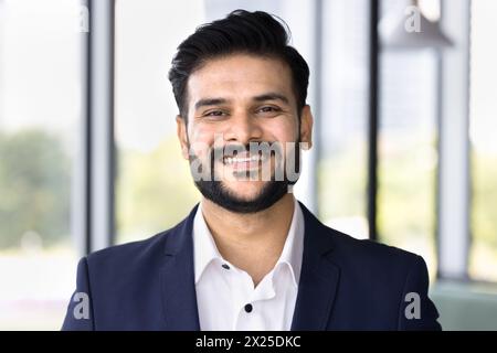 Happy successful young Indian businessman looking at camera Stock Photo