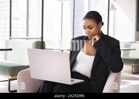 Thoughtful beautiful African business specialist woman using laptop Stock Photo