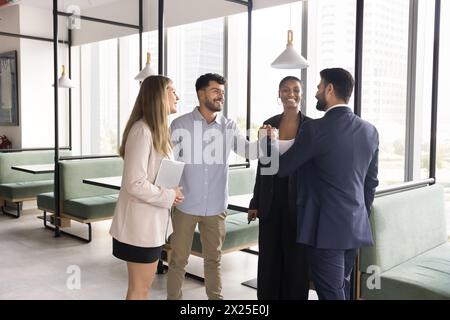 Positive diverse team of managers giving friends handshake Stock Photo