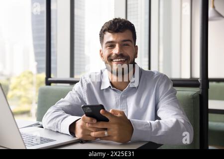 Happy young Arab freelancer man using gadgets for online work Stock Photo